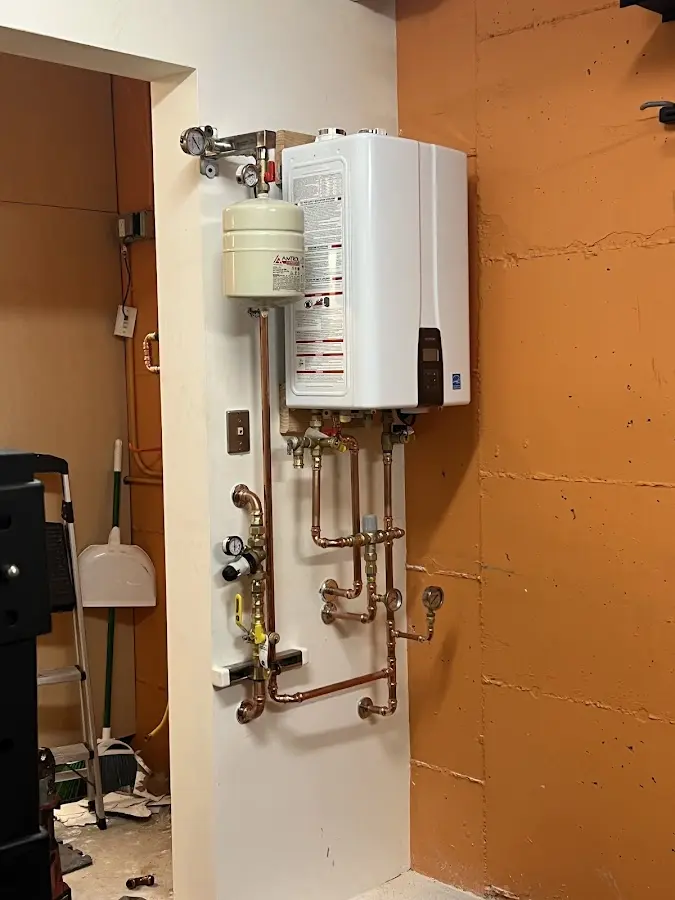Plumbing technician inspecting water heater connections in Harbor Bluffs